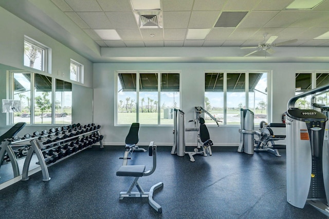 gym featuring ceiling fan and a drop ceiling