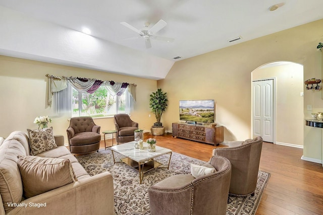 living area with baseboards, visible vents, arched walkways, a ceiling fan, and wood finished floors