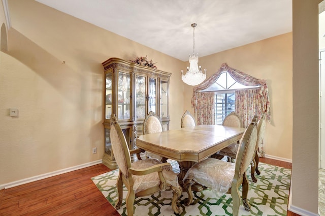 dining room featuring an inviting chandelier, baseboards, and wood finished floors