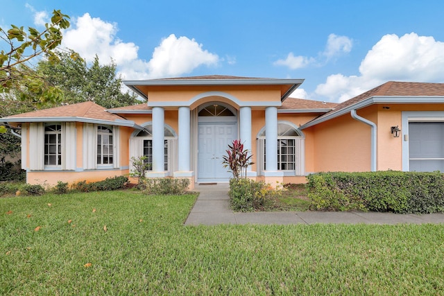 view of front of home featuring a garage, a front yard, and stucco siding