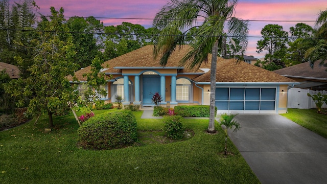 view of front of house with a garage, fence, concrete driveway, stucco siding, and a front yard