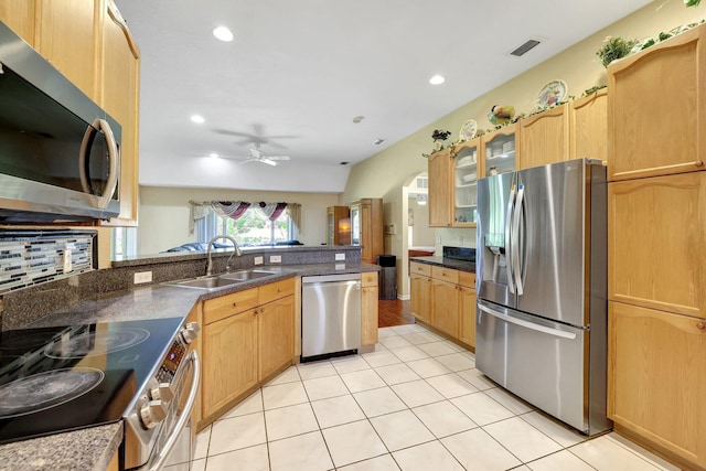 kitchen with light tile patterned floors, stainless steel appliances, visible vents, glass insert cabinets, and a sink