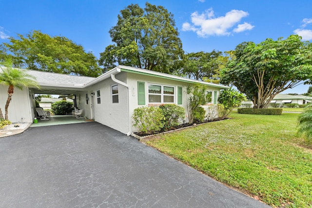 view of front of house with a carport and a front lawn