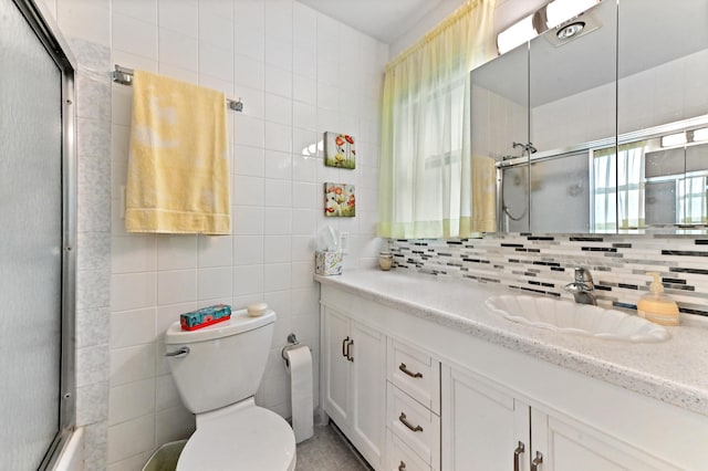 full bathroom featuring backsplash, tile walls, vanity, toilet, and enclosed tub / shower combo