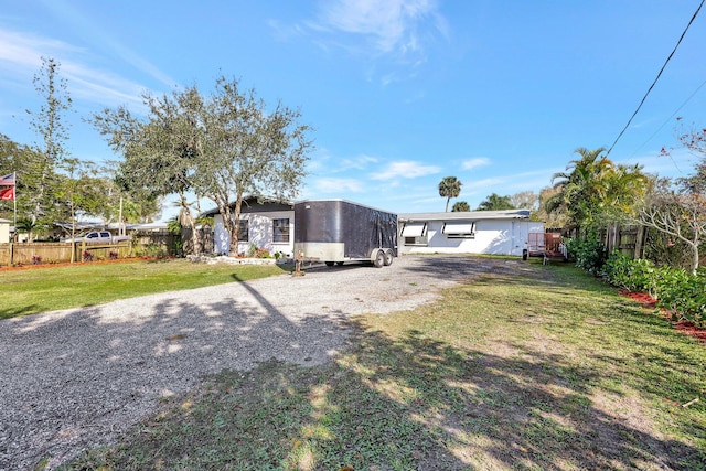 view of yard featuring gravel driveway and fence