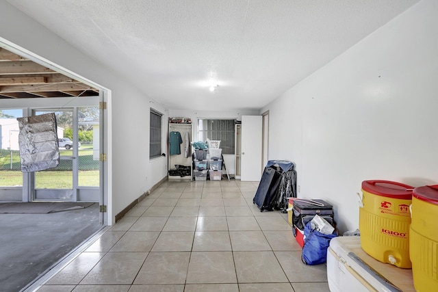 interior space with light tile patterned floors and a textured ceiling