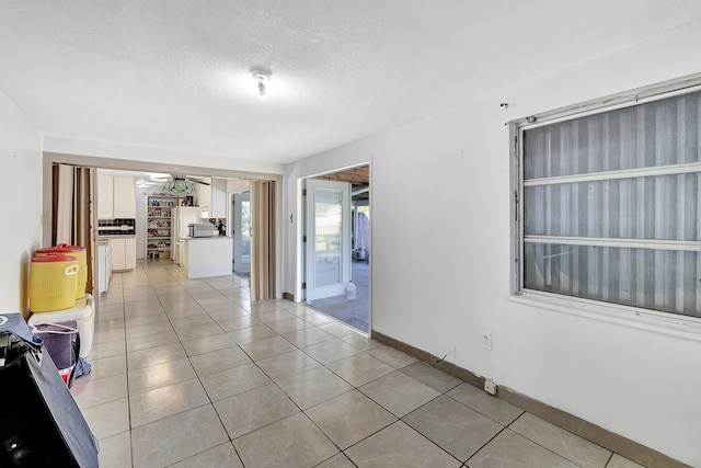 unfurnished room featuring light tile patterned floors and a textured ceiling