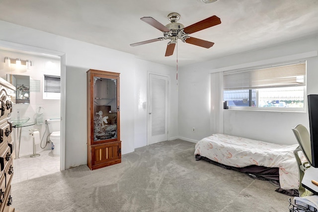 carpeted bedroom featuring ceiling fan, a closet, and ensuite bath