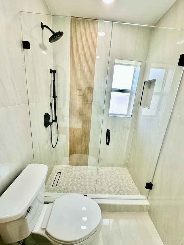 bathroom featuring a shower with shower door, toilet, and tile patterned flooring