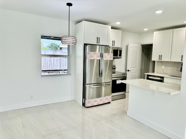 kitchen featuring backsplash, white cabinetry, hanging light fixtures, appliances with stainless steel finishes, and light stone counters