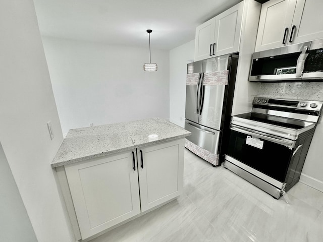 kitchen featuring light stone counters, white cabinets, hanging light fixtures, and appliances with stainless steel finishes