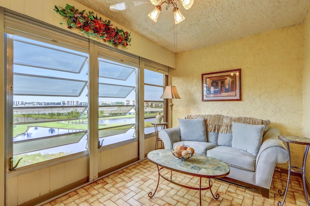 interior space with a wealth of natural light, a water view, and ceiling fan