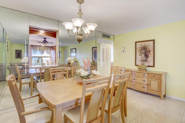 dining space with ceiling fan with notable chandelier, light tile patterned floors, and a textured ceiling