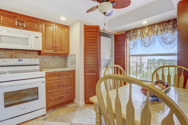 kitchen with decorative backsplash, light stone counters, ceiling fan, and white appliances