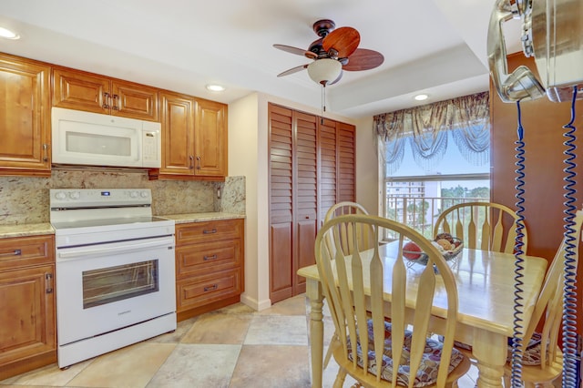 kitchen with ceiling fan, light stone counters, white appliances, and tasteful backsplash