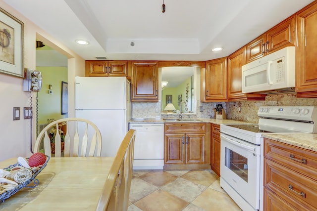 kitchen featuring decorative backsplash, white appliances, a raised ceiling, and sink