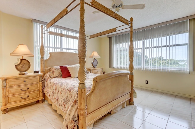 tiled bedroom with ceiling fan and a textured ceiling