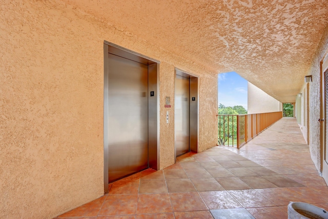 hall featuring elevator and brick ceiling