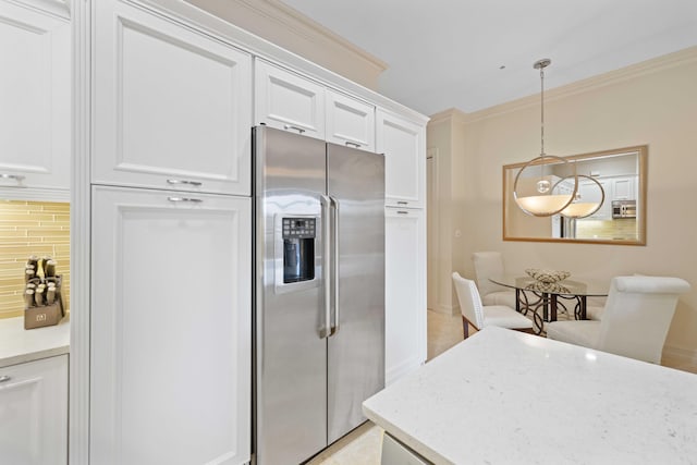 kitchen with stainless steel fridge, backsplash, light stone counters, decorative light fixtures, and white cabinets