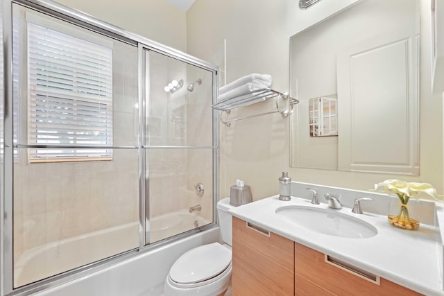 full bathroom with vanity, toilet, and bath / shower combo with glass door