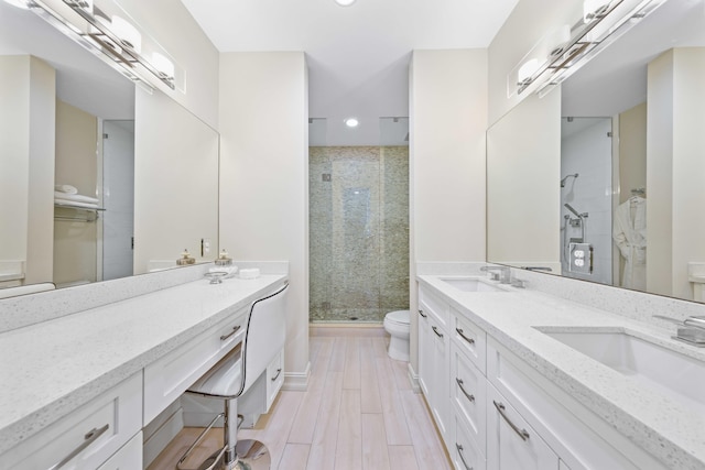 bathroom featuring hardwood / wood-style floors, vanity, a shower with shower door, and toilet