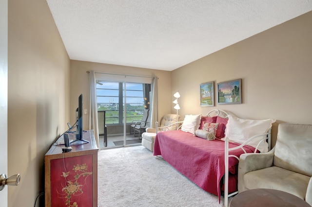 carpeted bedroom featuring access to exterior and a textured ceiling