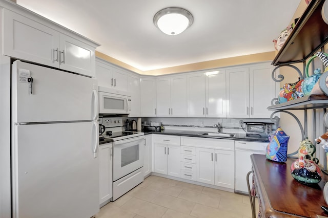 kitchen with tasteful backsplash, white appliances, sink, white cabinets, and light tile patterned flooring