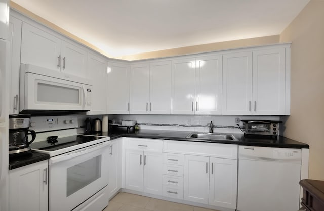 kitchen featuring white cabinetry, light tile patterned flooring, white appliances, and sink