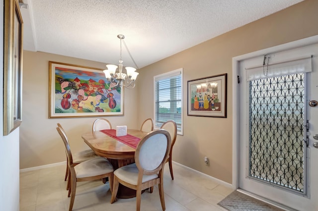 dining area with light tile patterned floors, a textured ceiling, and an inviting chandelier