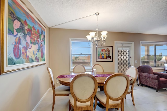 dining space with a chandelier and a textured ceiling