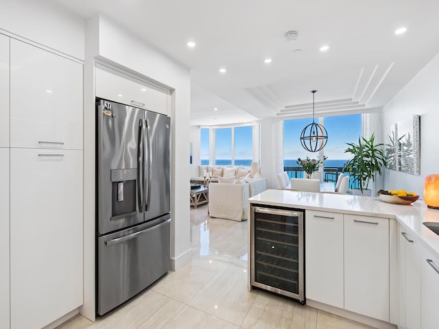 kitchen with white cabinetry, a wealth of natural light, hanging light fixtures, stainless steel fridge with ice dispenser, and wine cooler