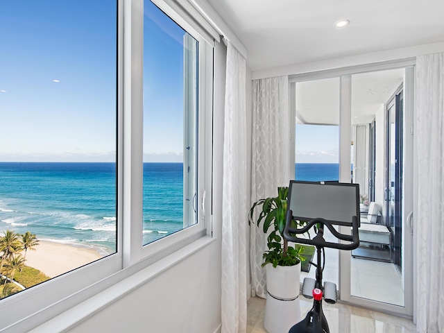 interior space featuring a beach view, a water view, and light tile patterned floors