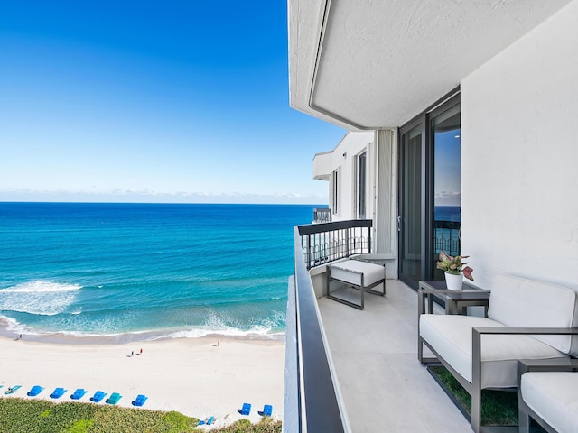 balcony featuring a beach view and a water view