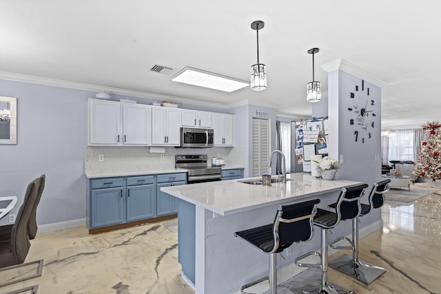 kitchen featuring sink, white cabinets, tasteful backsplash, pendant lighting, and appliances with stainless steel finishes