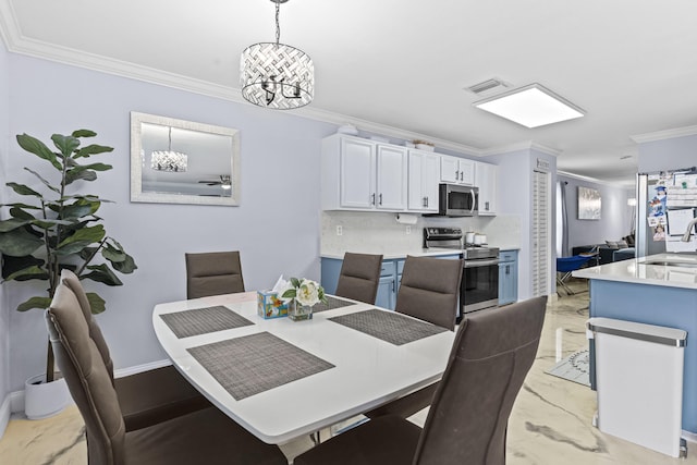 dining room featuring ornamental molding, a chandelier, and sink