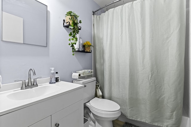 bathroom with curtained shower, vanity, and toilet