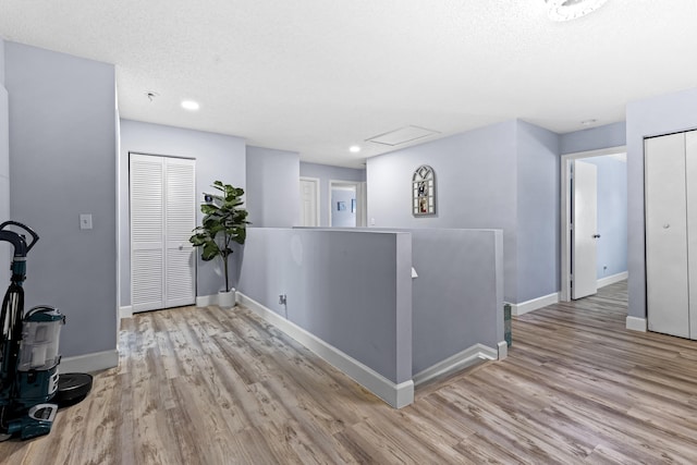 foyer entrance with a textured ceiling and light wood-type flooring