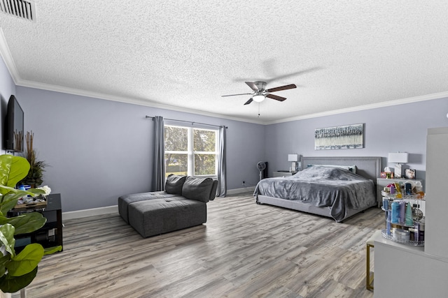 bedroom with a textured ceiling, ceiling fan, hardwood / wood-style flooring, and ornamental molding