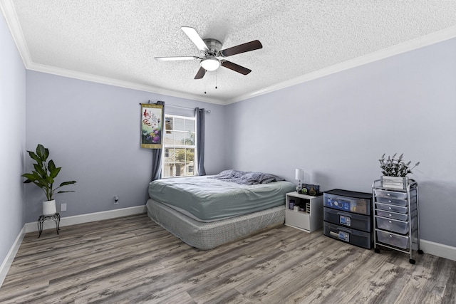 bedroom with wood-type flooring, a textured ceiling, ceiling fan, and crown molding