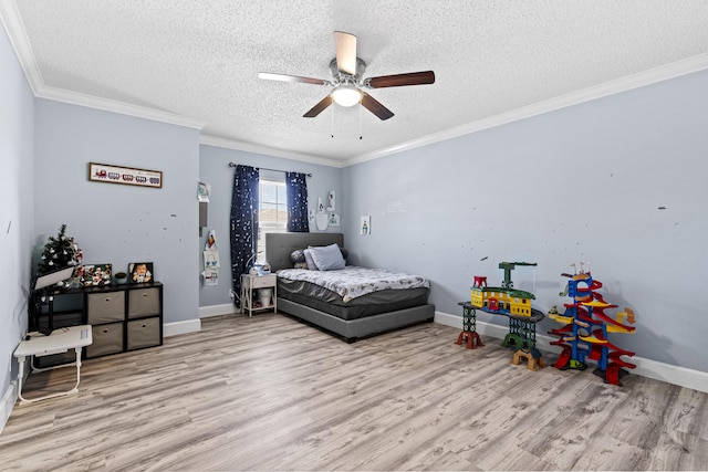 bedroom featuring a textured ceiling, ceiling fan, light hardwood / wood-style floors, and ornamental molding