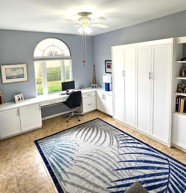 tiled home office with built in desk and ceiling fan