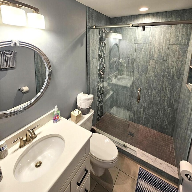 bathroom featuring tile patterned flooring, vanity, toilet, and an enclosed shower