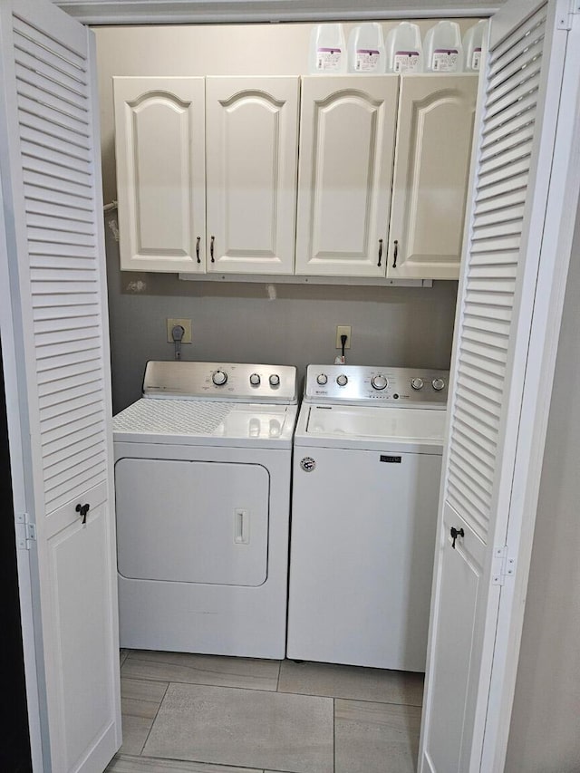 clothes washing area featuring cabinets and independent washer and dryer