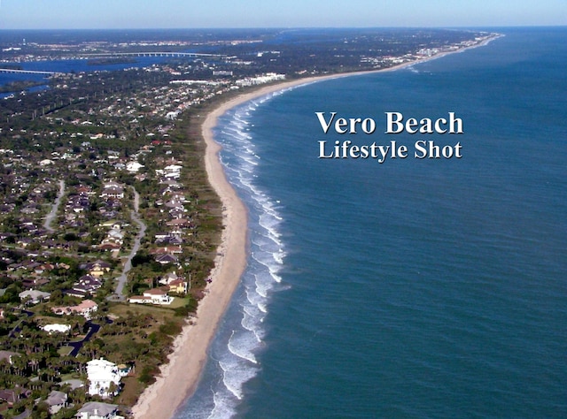 drone / aerial view with a water view and a beach view