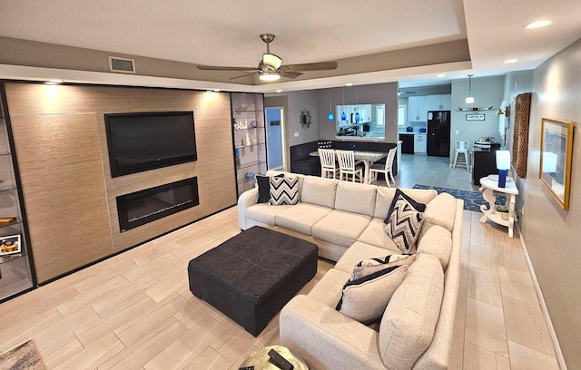 living room featuring light wood-type flooring and ceiling fan