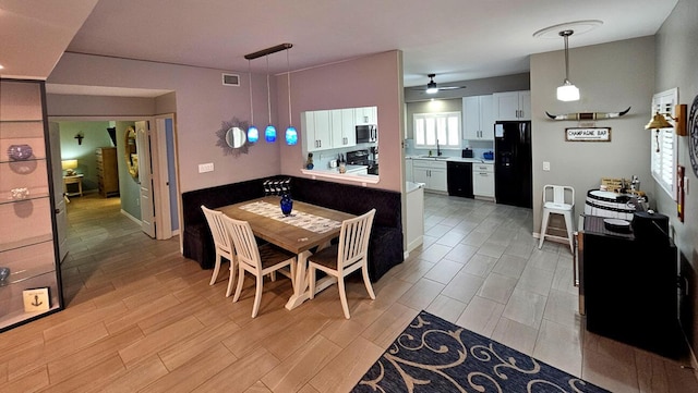 dining space featuring ceiling fan, sink, and a wealth of natural light