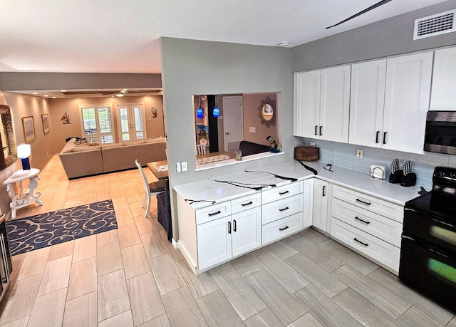 kitchen featuring black range with electric cooktop, white cabinetry, and ceiling fan