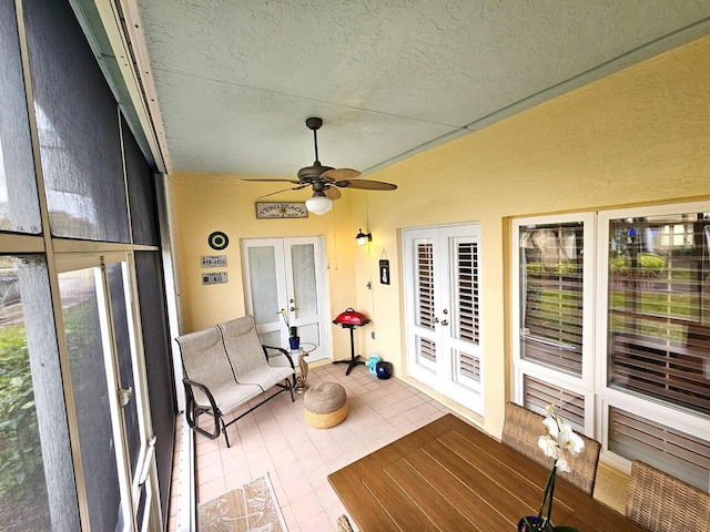 sunroom / solarium featuring ceiling fan and french doors