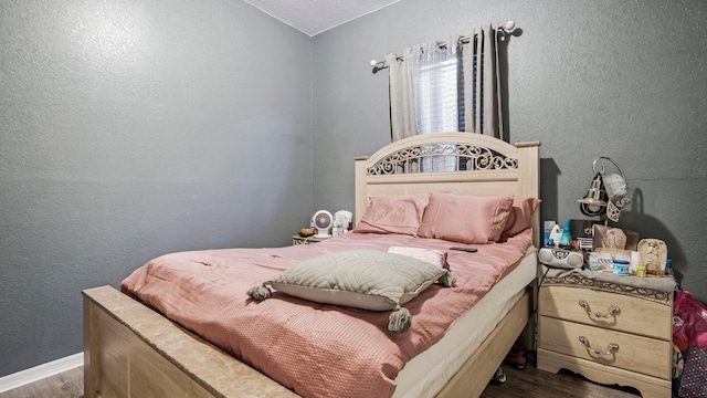 bedroom featuring a textured ceiling and dark hardwood / wood-style floors