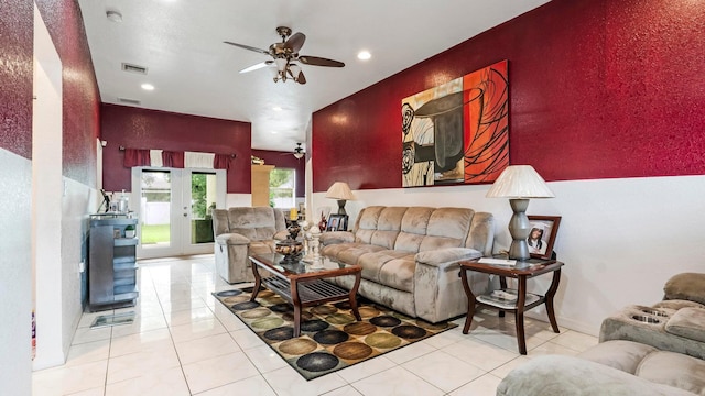 tiled living room with french doors and ceiling fan